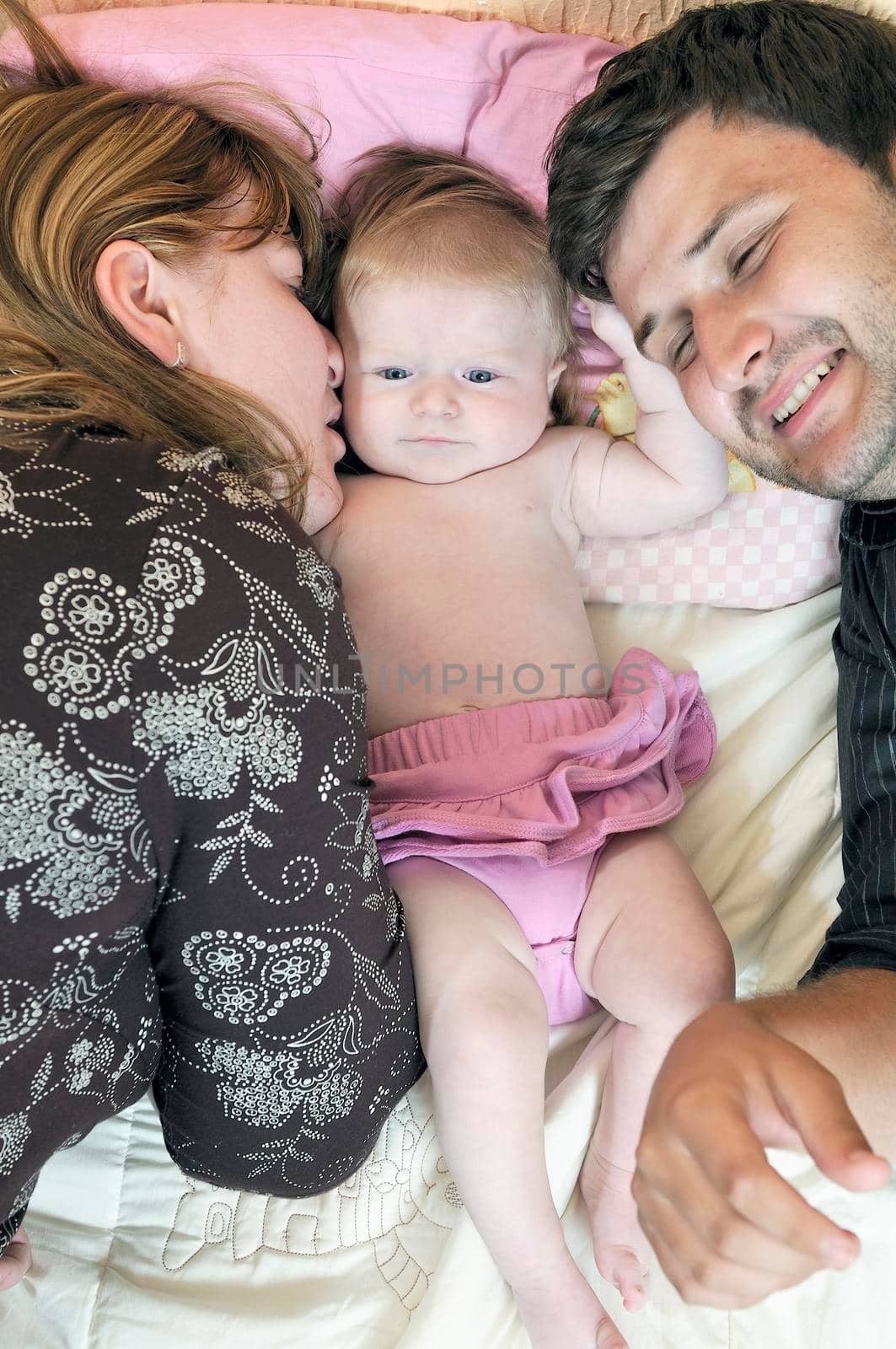 indoor portrait with happy young family and  cute little babby