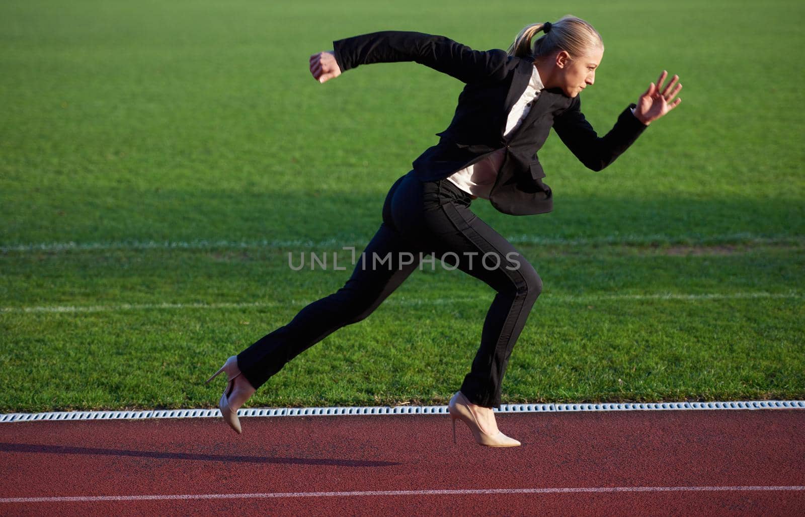 business man in start position ready to run and sprint on athletics racing track