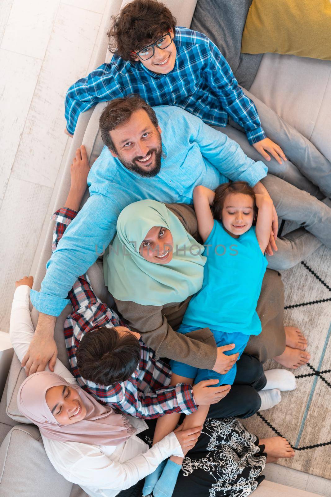 Top view photo of an Arab large family sitting in the living room of a modern house interior.Selective focus. High quality photo