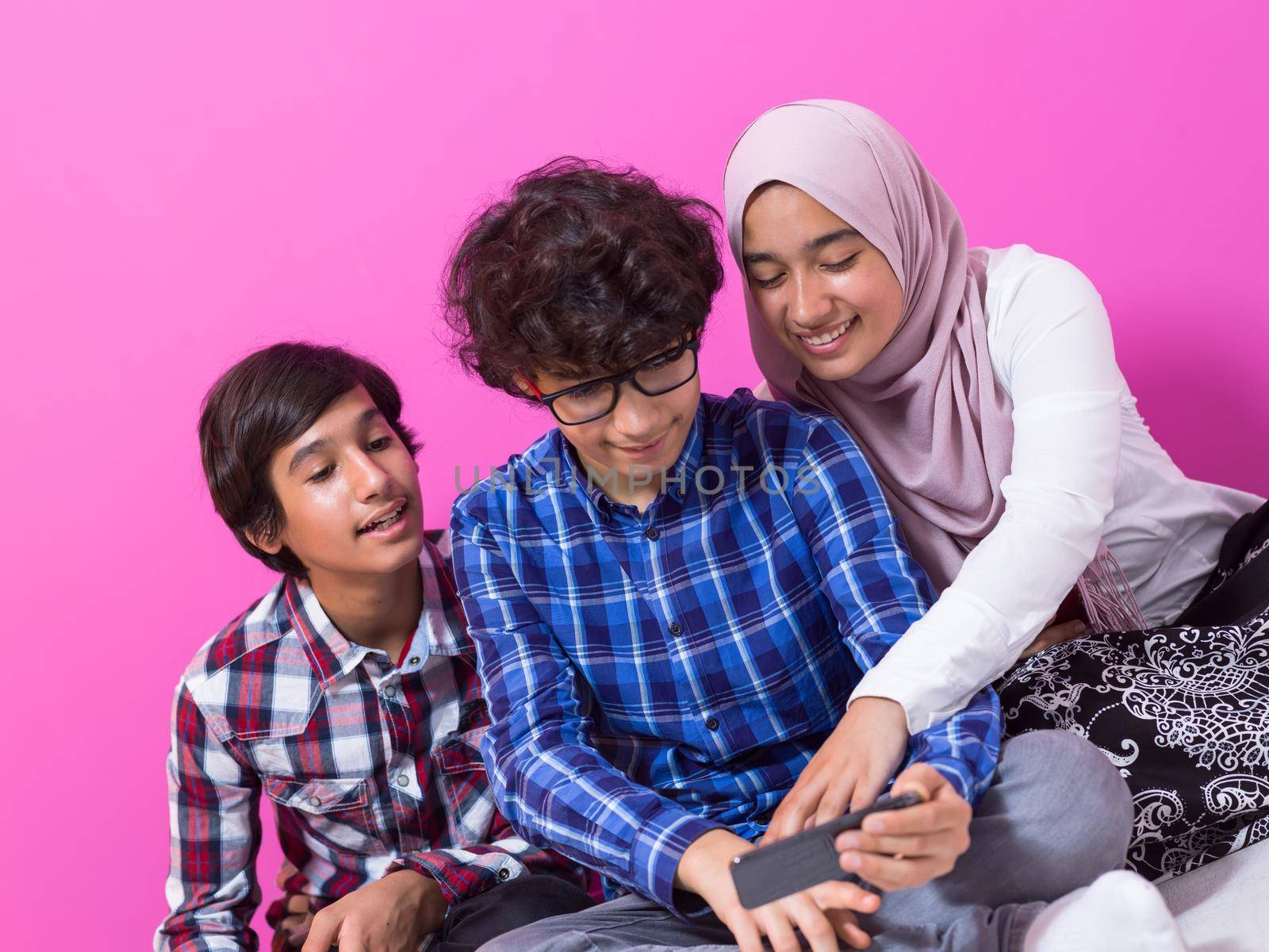 Arab teenagers group using smartphones for social media networking and sharing information for online education. Selective focus. High quality photo