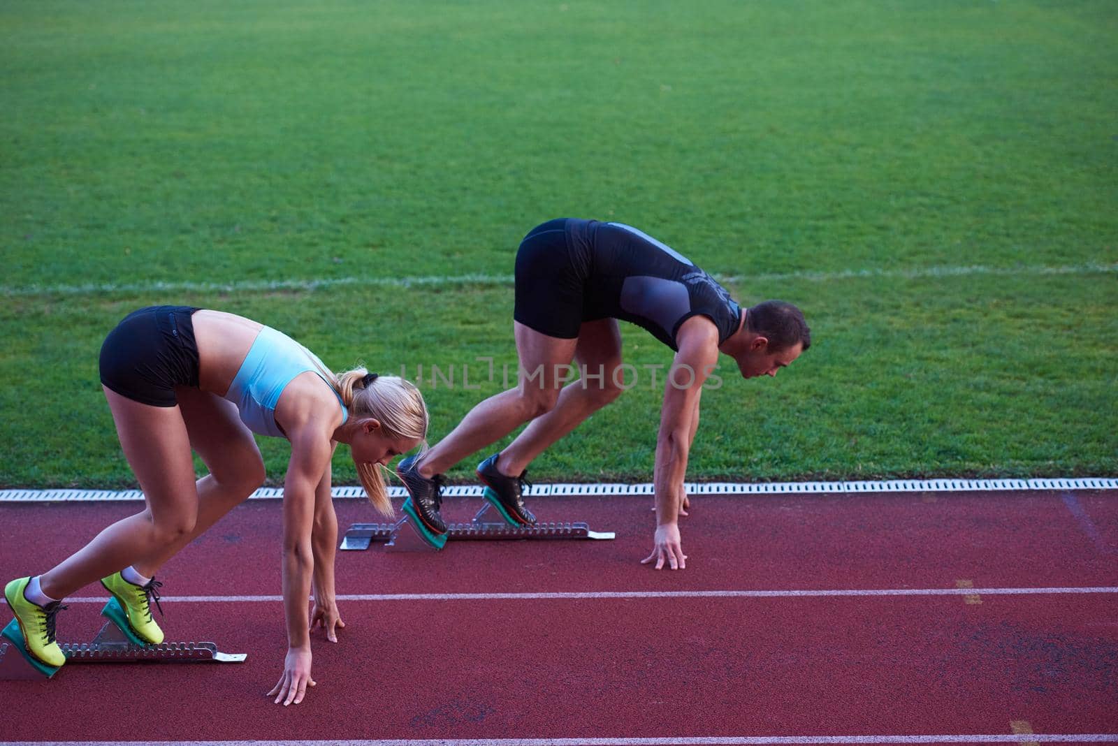 athlete woman group  running on athletics race track on soccer stadium and representing competition and leadership concept in sport