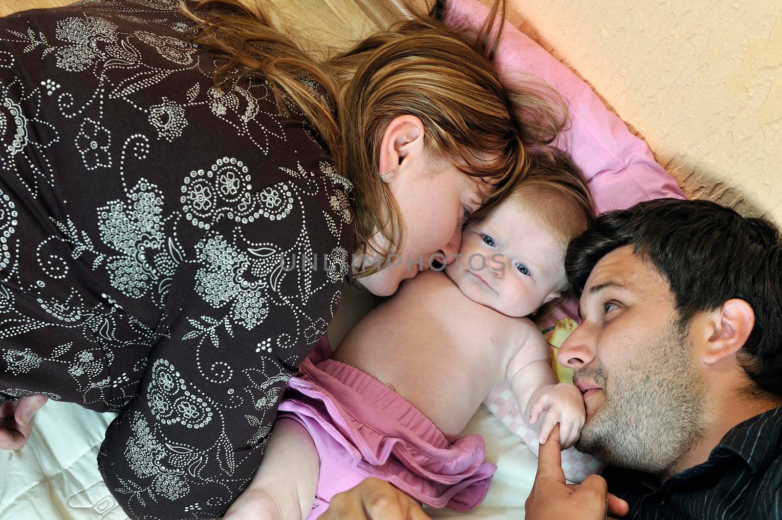 indoor portrait with happy young family and  cute little babby