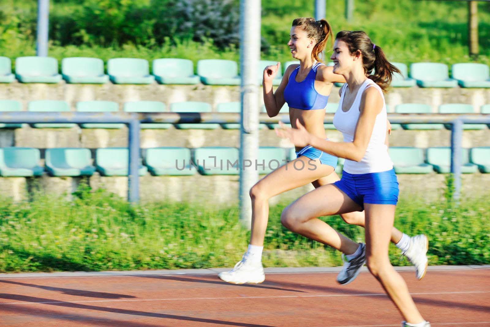 young girl morning run and competition on athletic race track