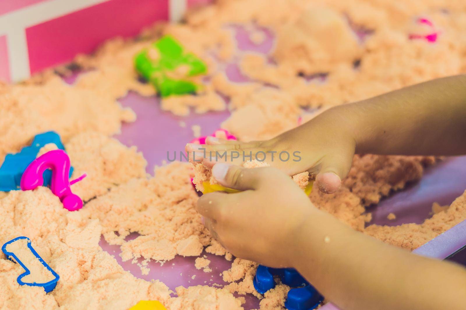 Boy playing with kinetic sand in preschool. The development of fine motor concept. Creativity Game concept.