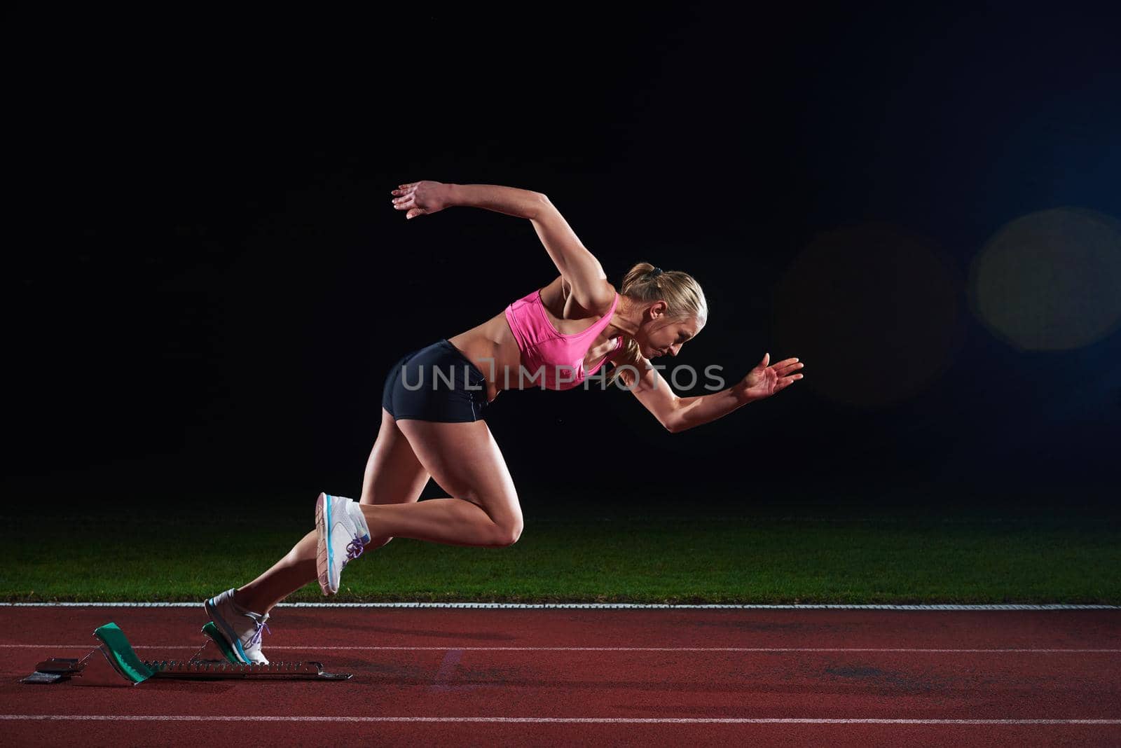 pixelated design of woman  sprinter leaving starting blocks on the athletic  track. Side view. exploding start