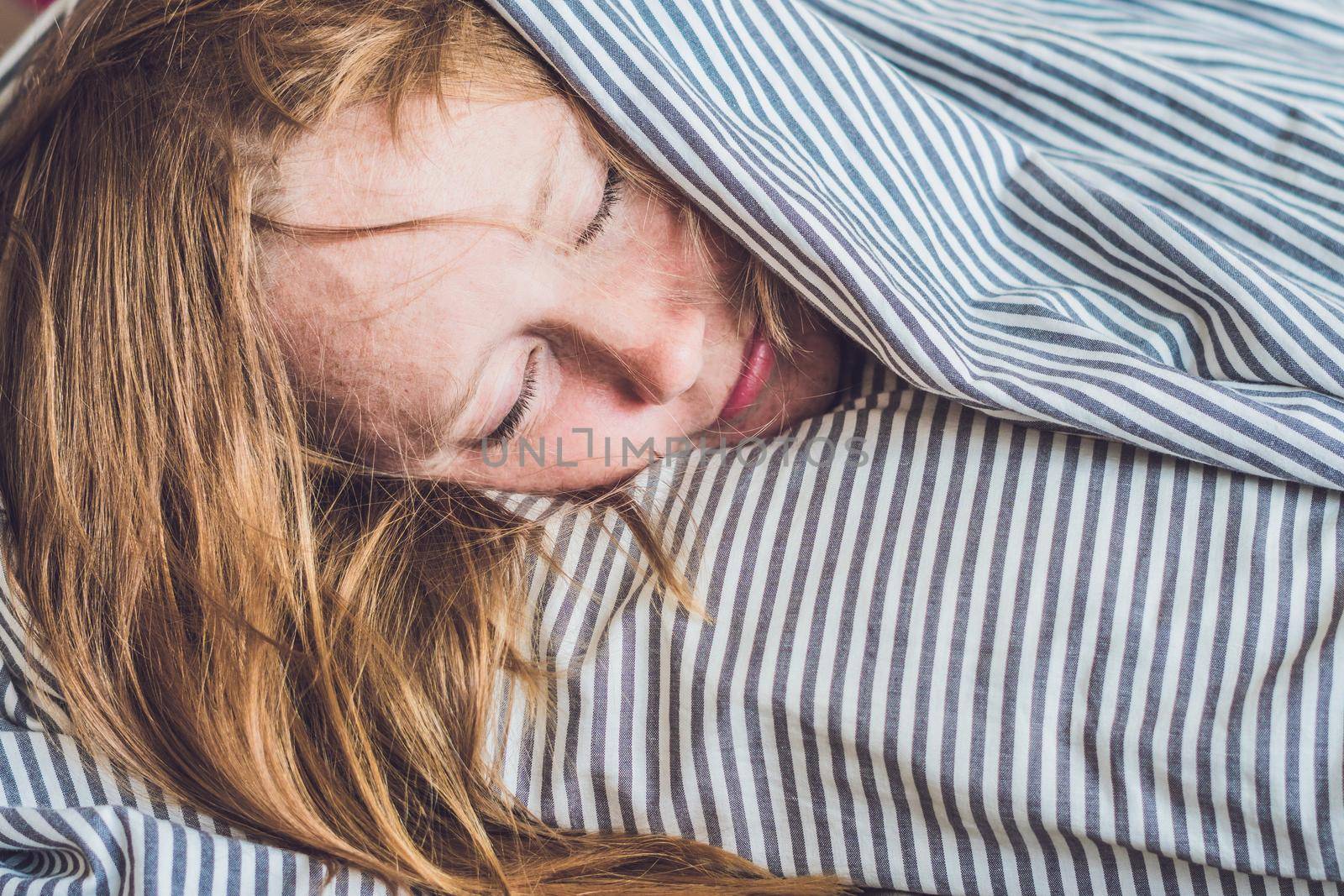 Beautiful young woman lying down in bed and sleeping. Do not get enough sleep concept.