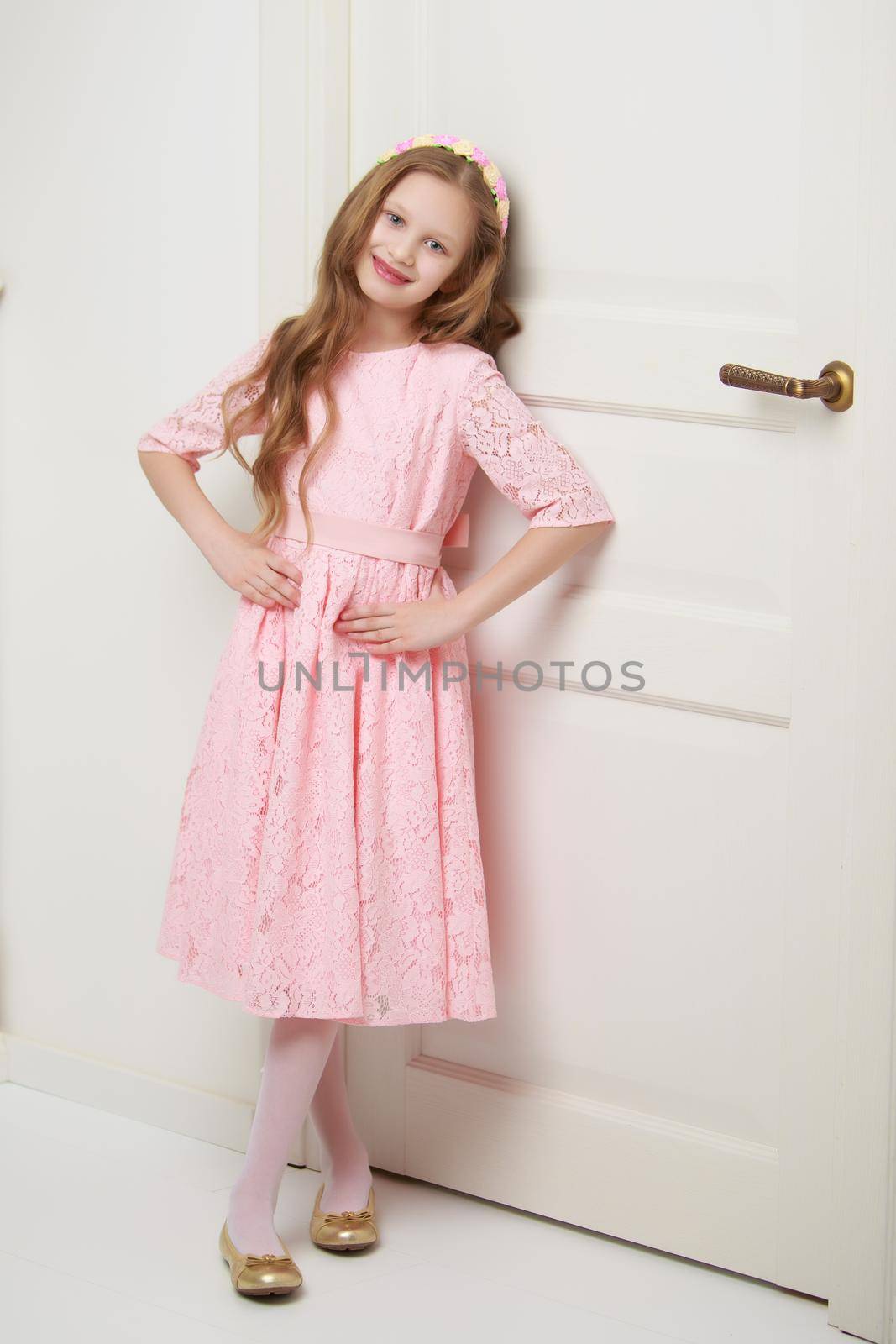 A little girl is standing by the door. by kolesnikov_studio