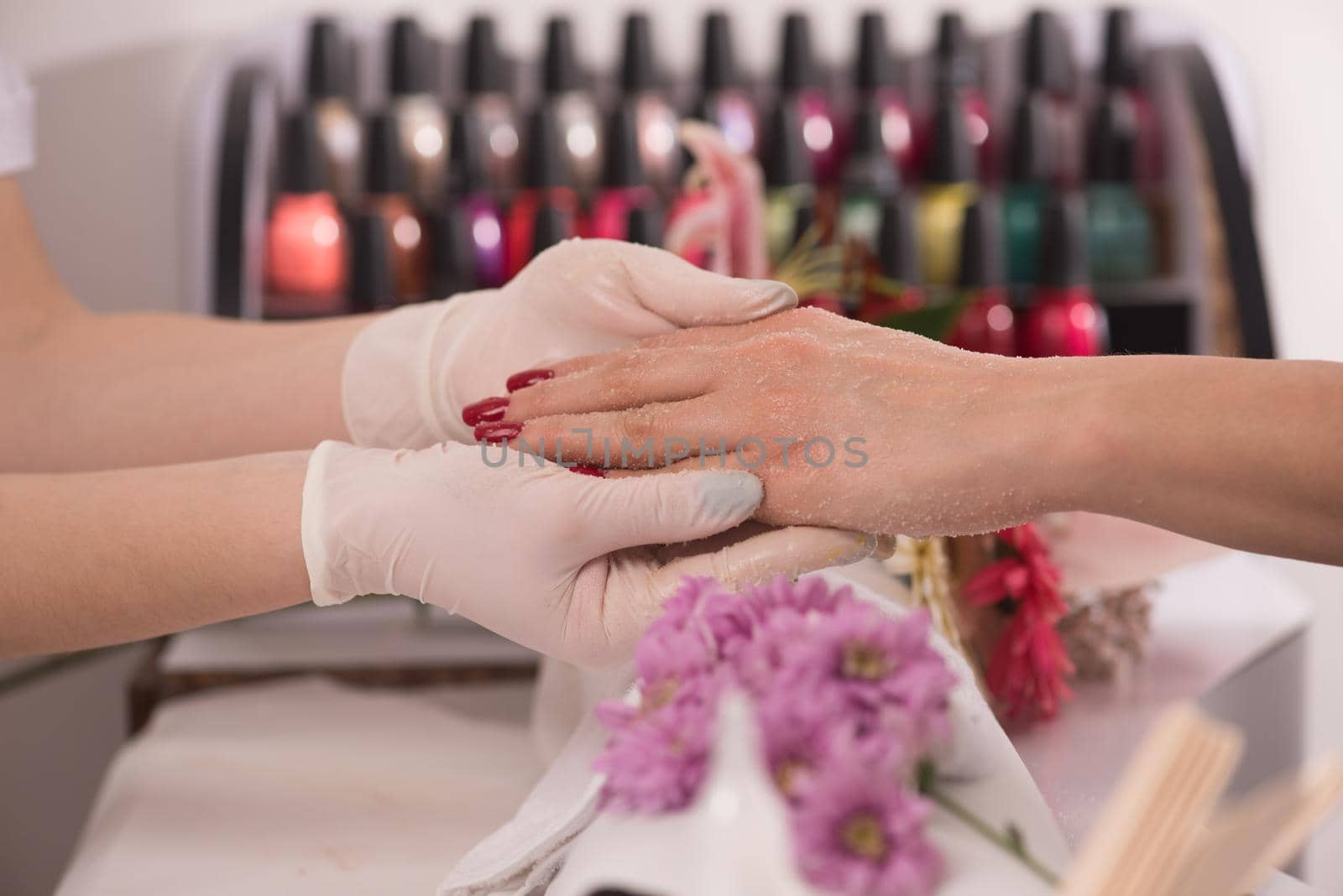 Woman hands receiving a manicure in beauty salon. Nail filing. Close up, selective focus.