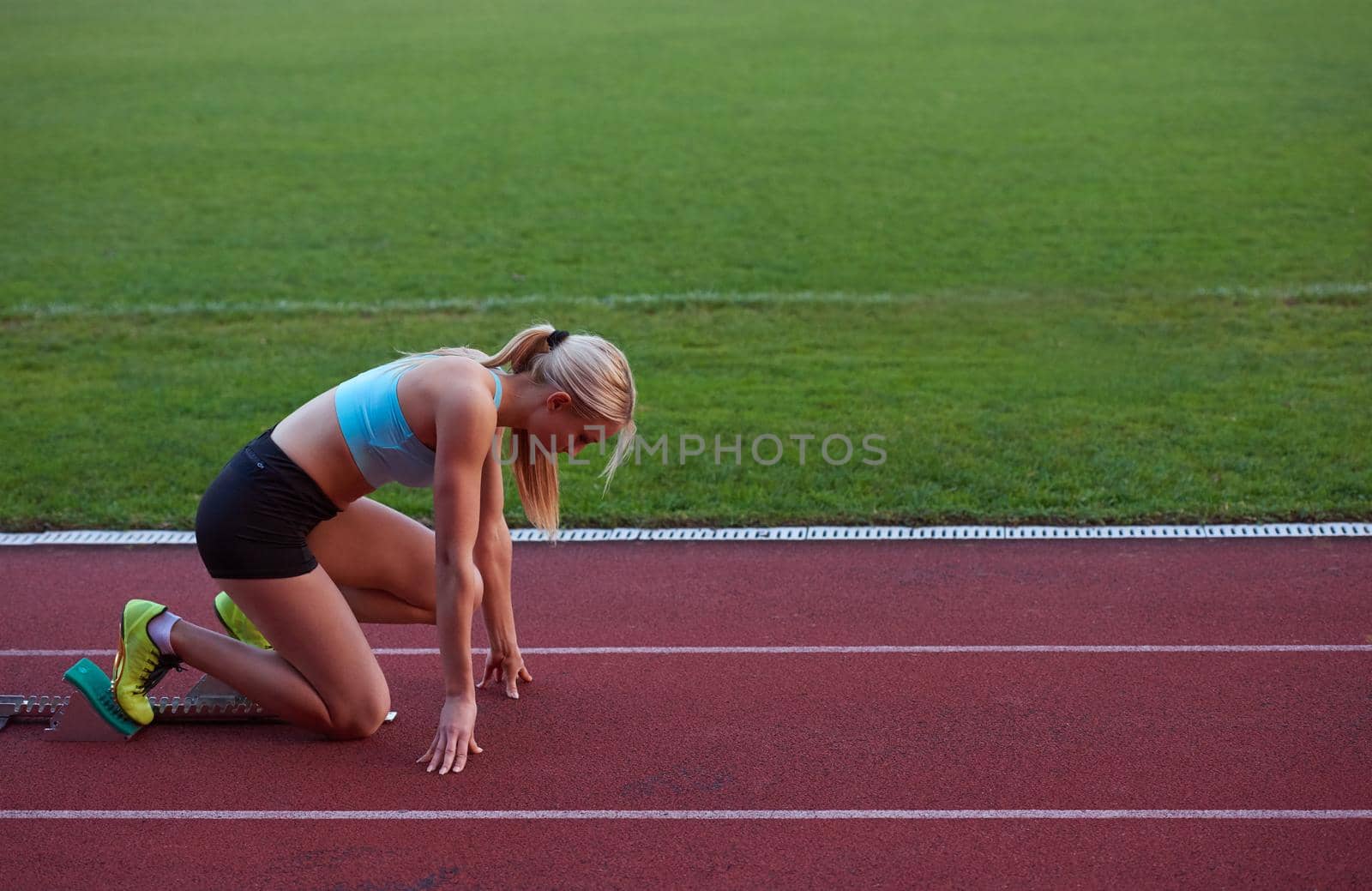 athlete woman group  running on athletics race track by dotshock