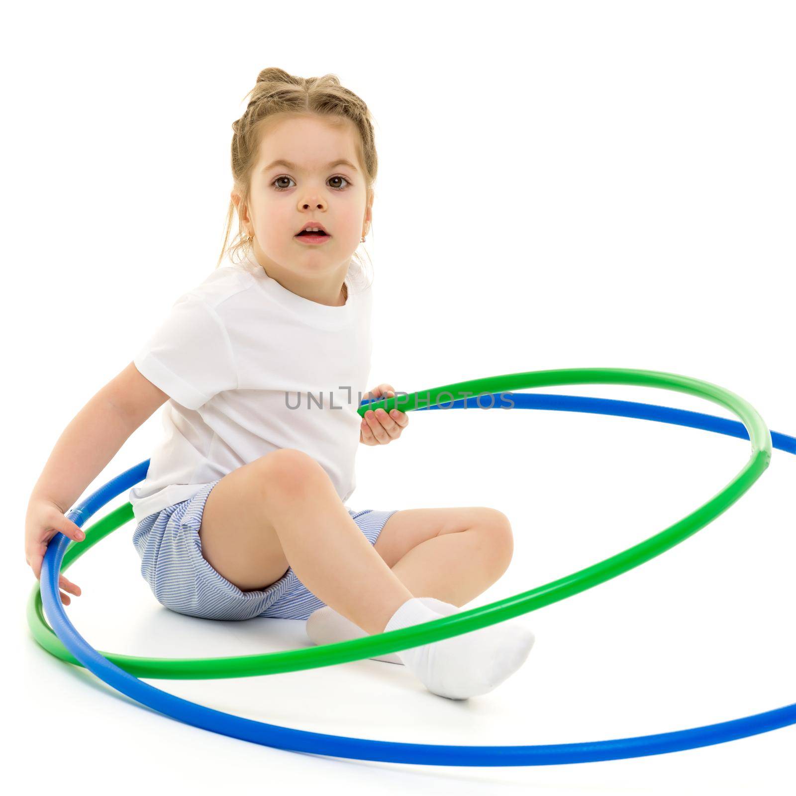 Beautiful little girl in a pure white T-shirt, on which you can write a logo or any other text that plays with a hoop. The concept of advertising, children's sports. Isolated on white background