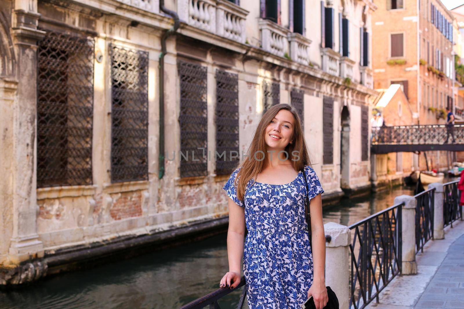 Young girl tourist sitting on banister in Venice, Italy. by sisterspro