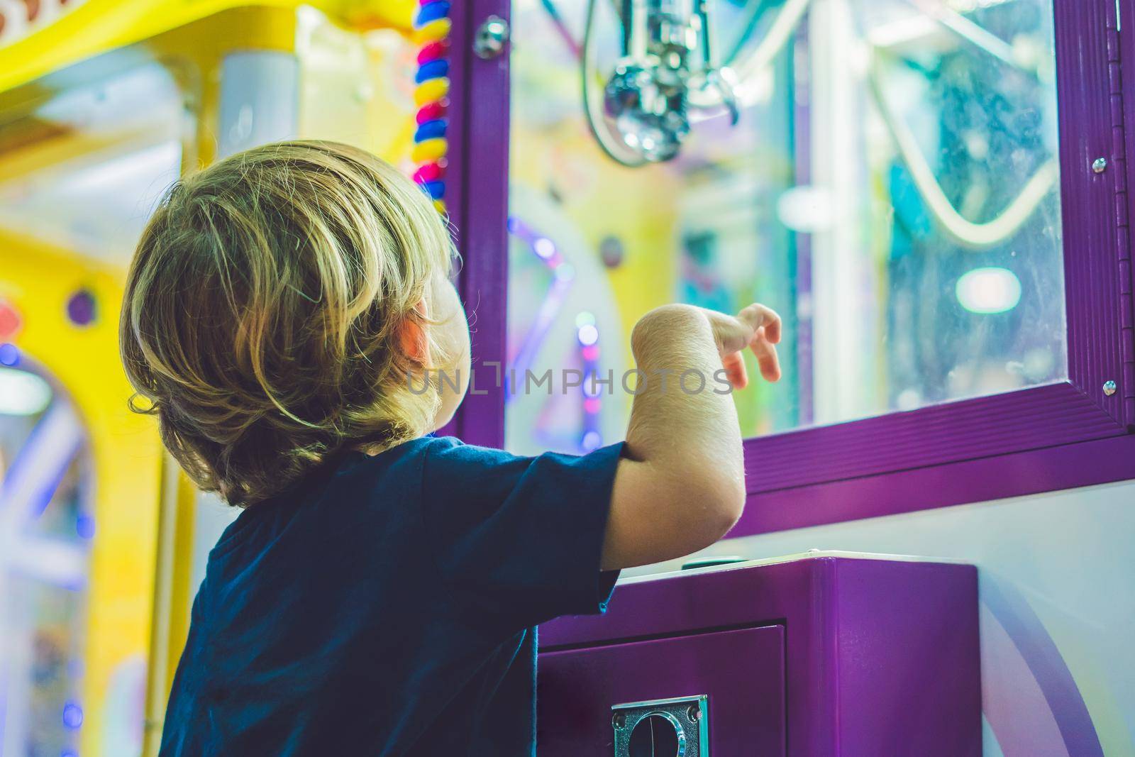 The boy plays with the vending machine.