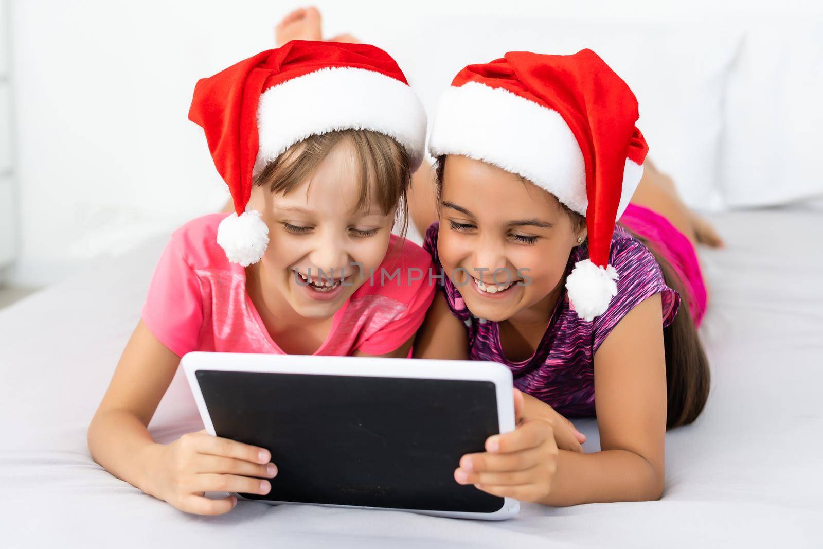 New year concept. christmas, x-mas, winter, happiness concept - two adorable cute girls playing with tablet pc.