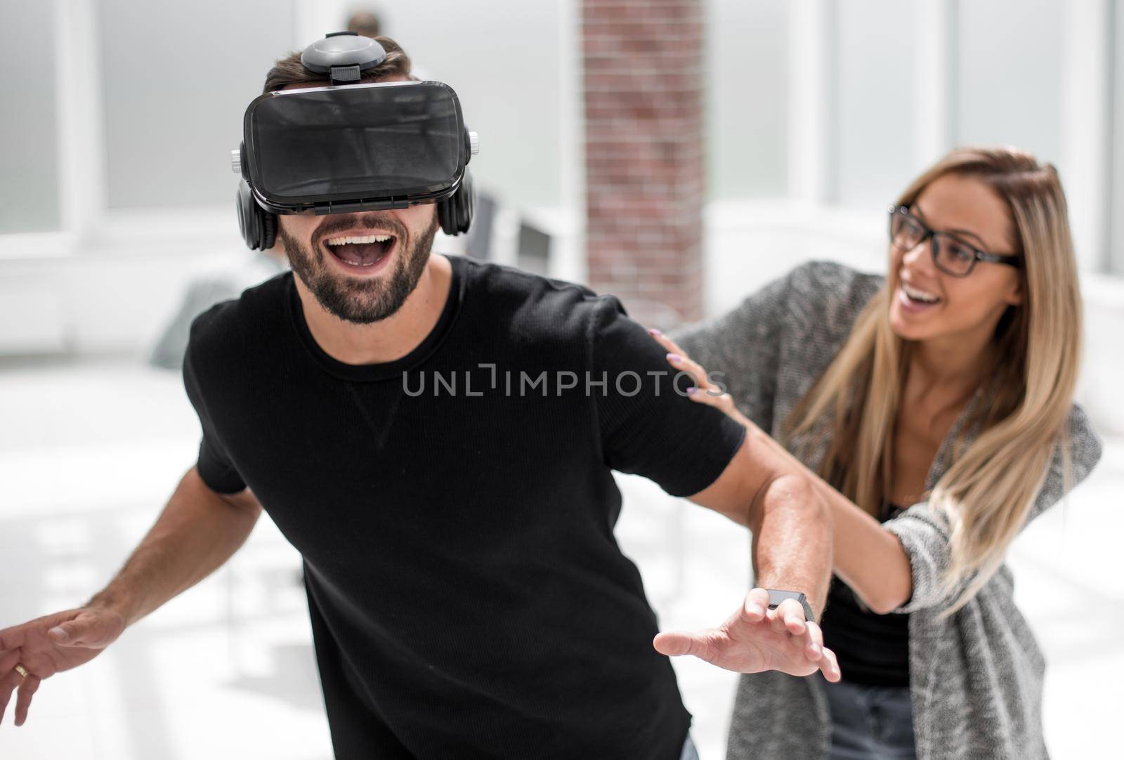 Positive man wearing virtual reality glasses and smiling while testing new technology