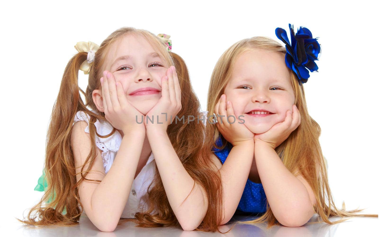 Cute little girls sisters lying on the floor . Resting his head on his hands - Isolated on white background