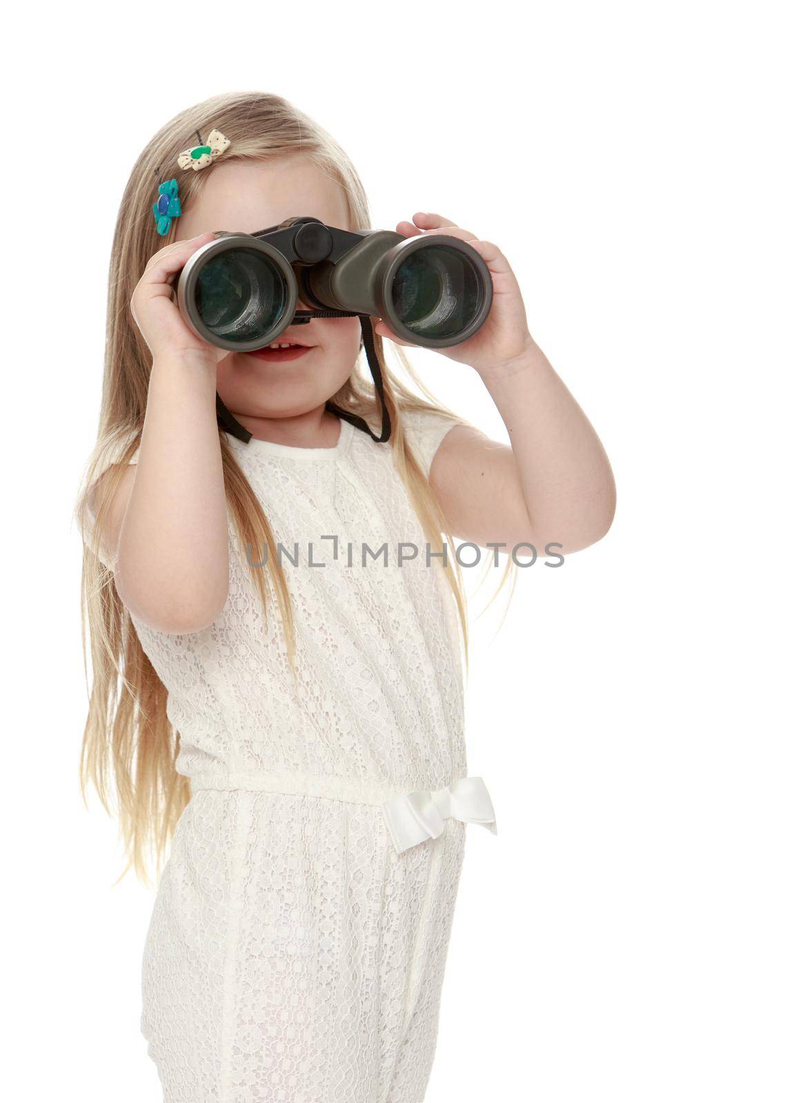 Beautiful little girl with long blond hair below the shoulders , in a white jumpsuit , keep the angle big binoculars . the girl looks straight into the camera. Close-up - Isolated on white background