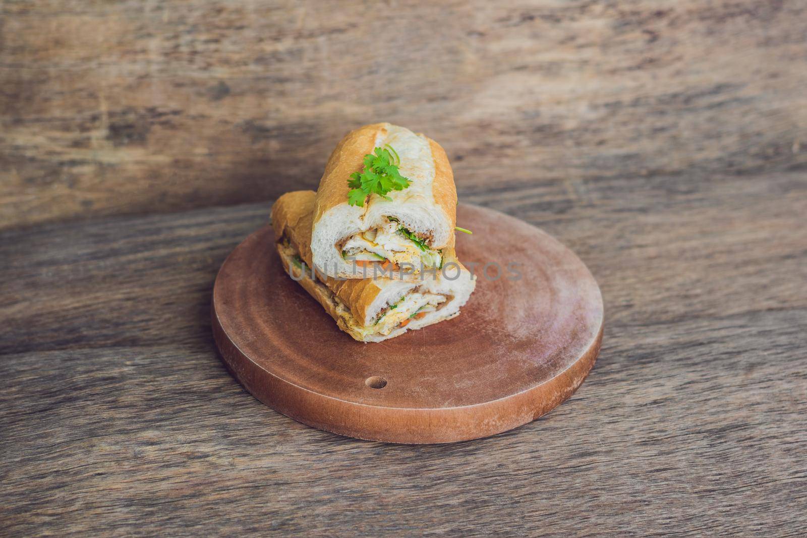A delicious Vietnamese Bahn Mi sandwich on a wooden background.