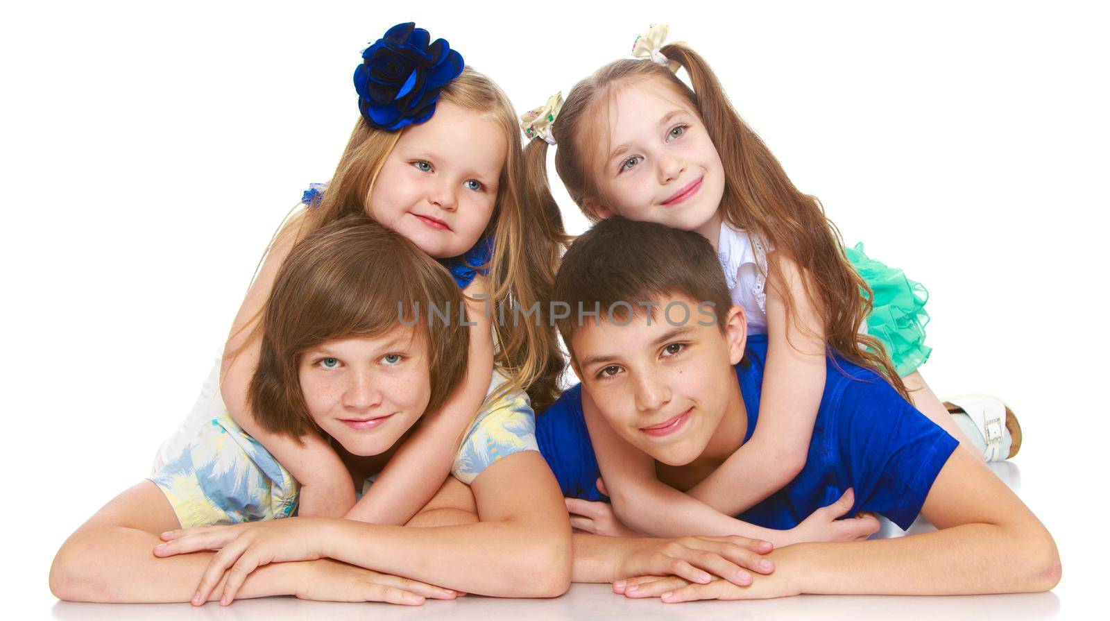 Horizontally elongated rectangular frame. Two little girls sisters lie on top of his brothers and hugging them around the neck. The picture shows 4 children - Isolated on white background