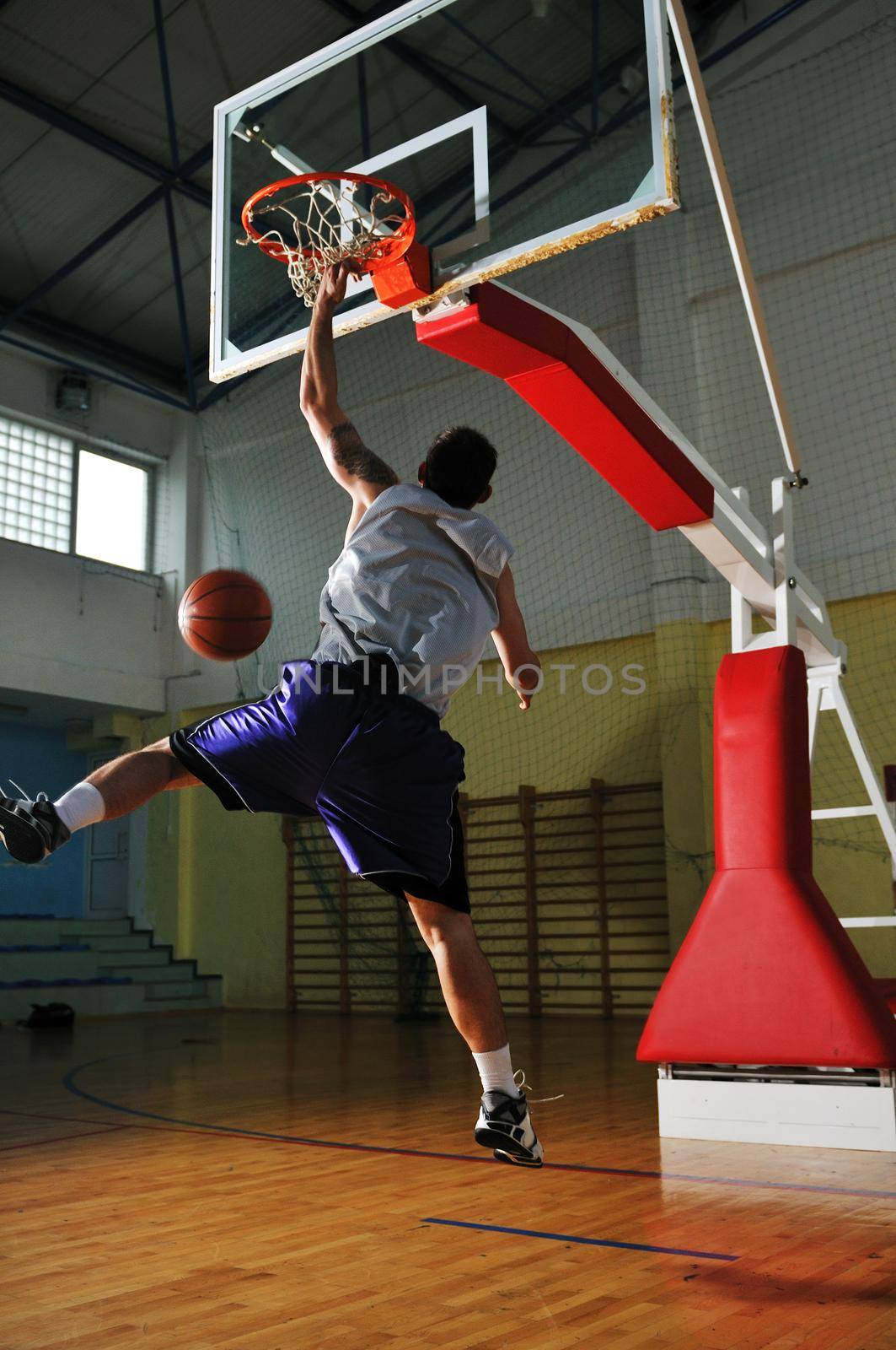 one healthy young  man play basketball game in school gym indoor