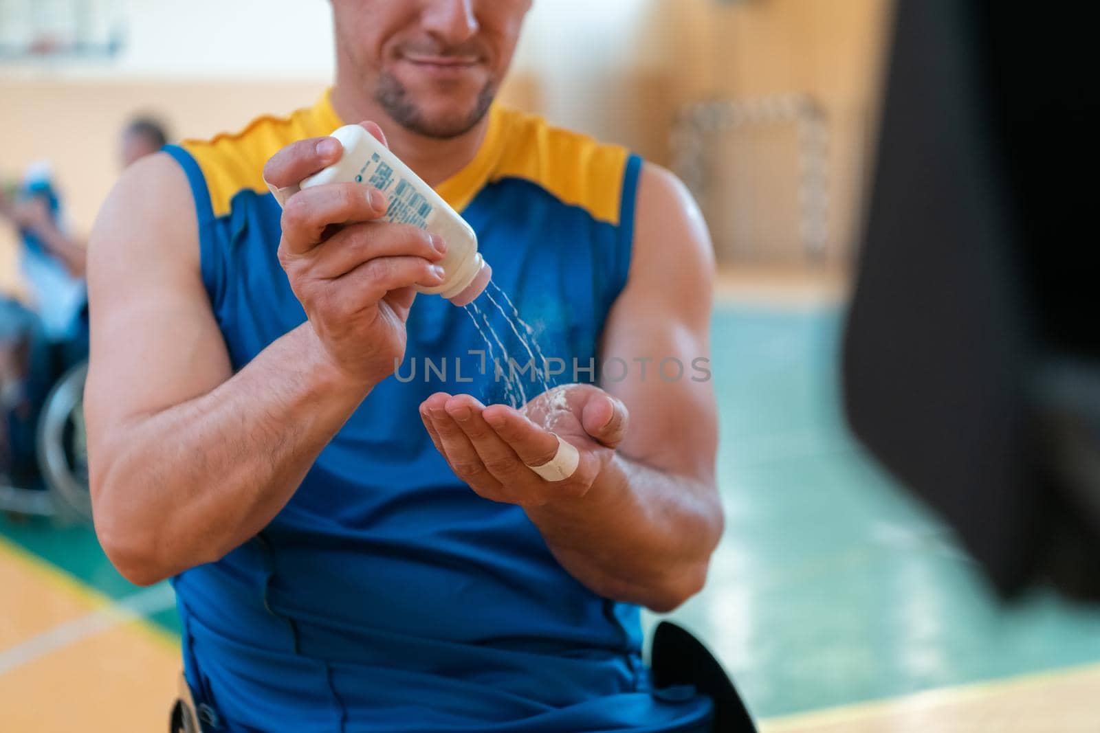 a basketball player puts anti-slip powder before the start of a basketball game by dotshock