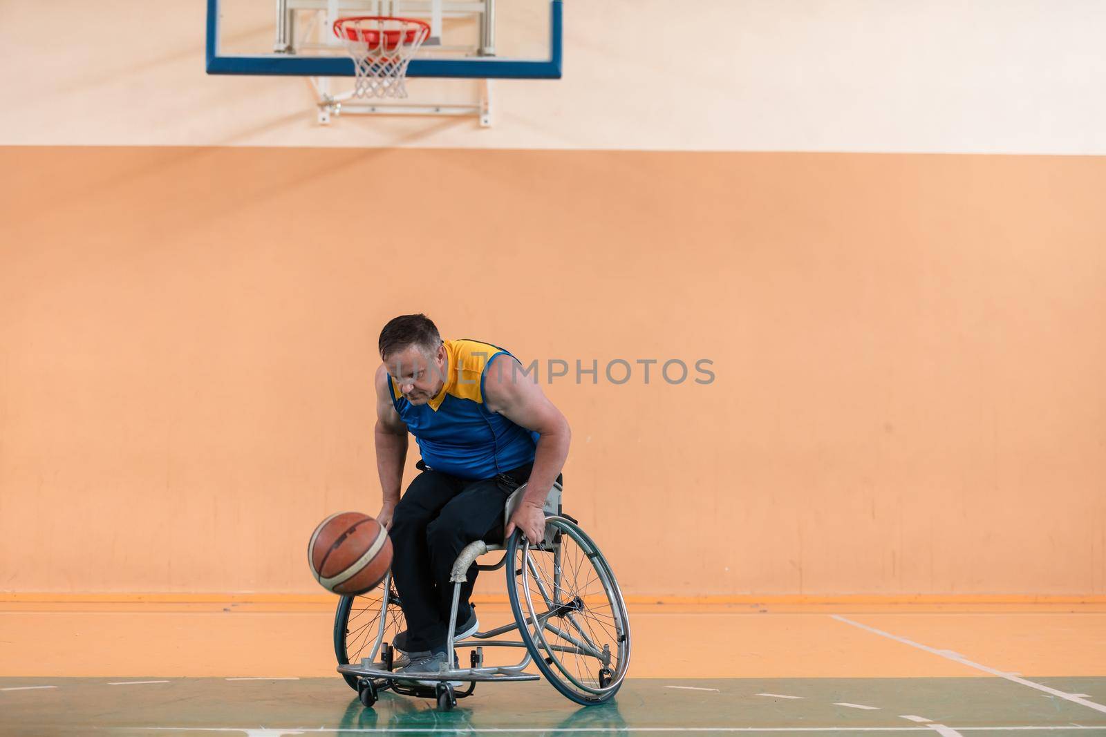 Disabled War or work veterans mixed race and age basketball teams in wheelchairs playing a training match in a sports gym hall. Handicapped people rehabilitation and inclusion concept.Hi quality photo