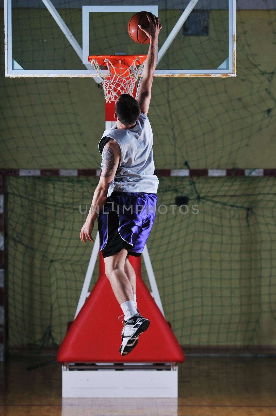 one healthy young  man play basketball game in school gym indoor