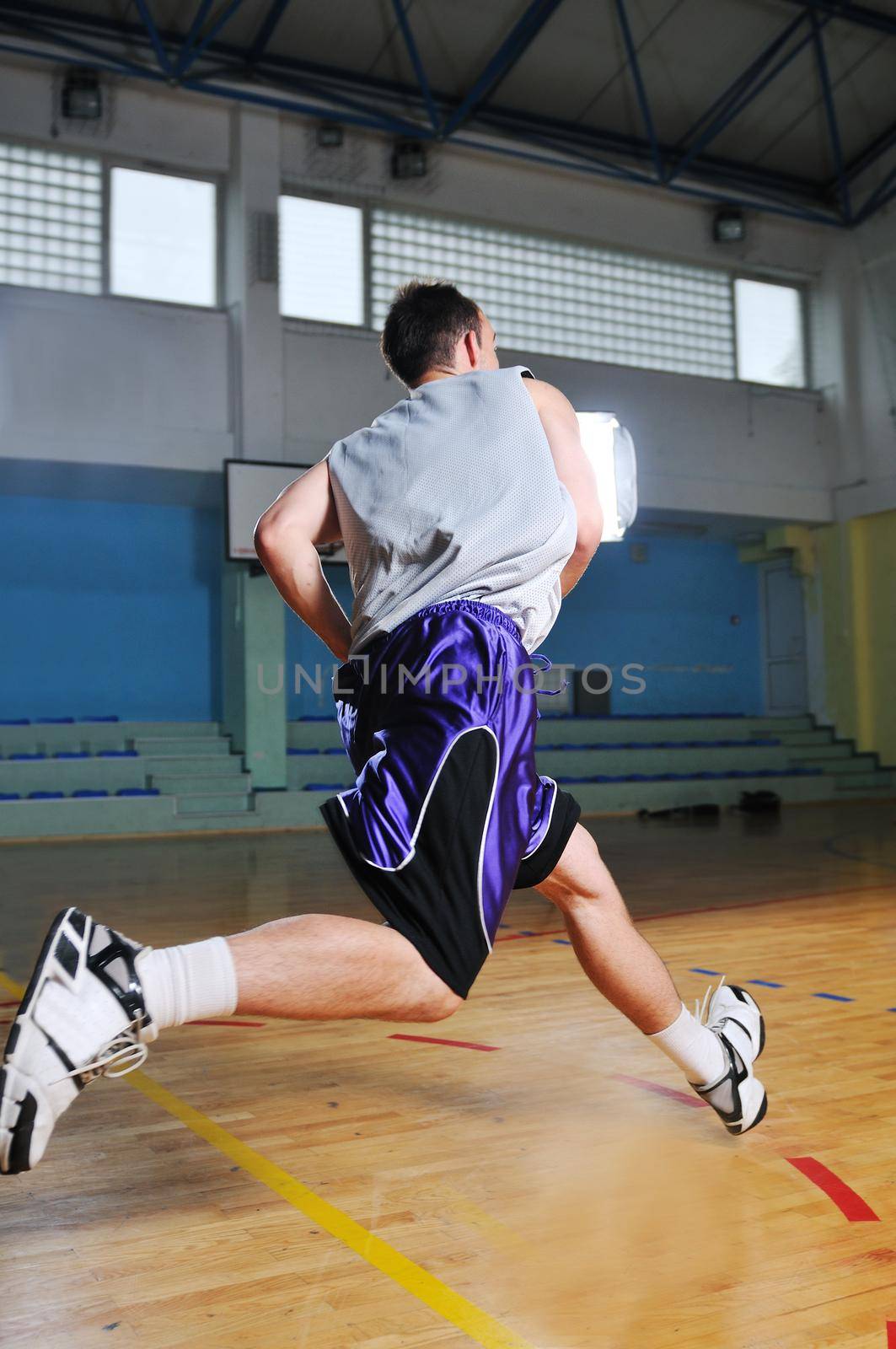 one healthy young  man play basketball game in school gym indoor