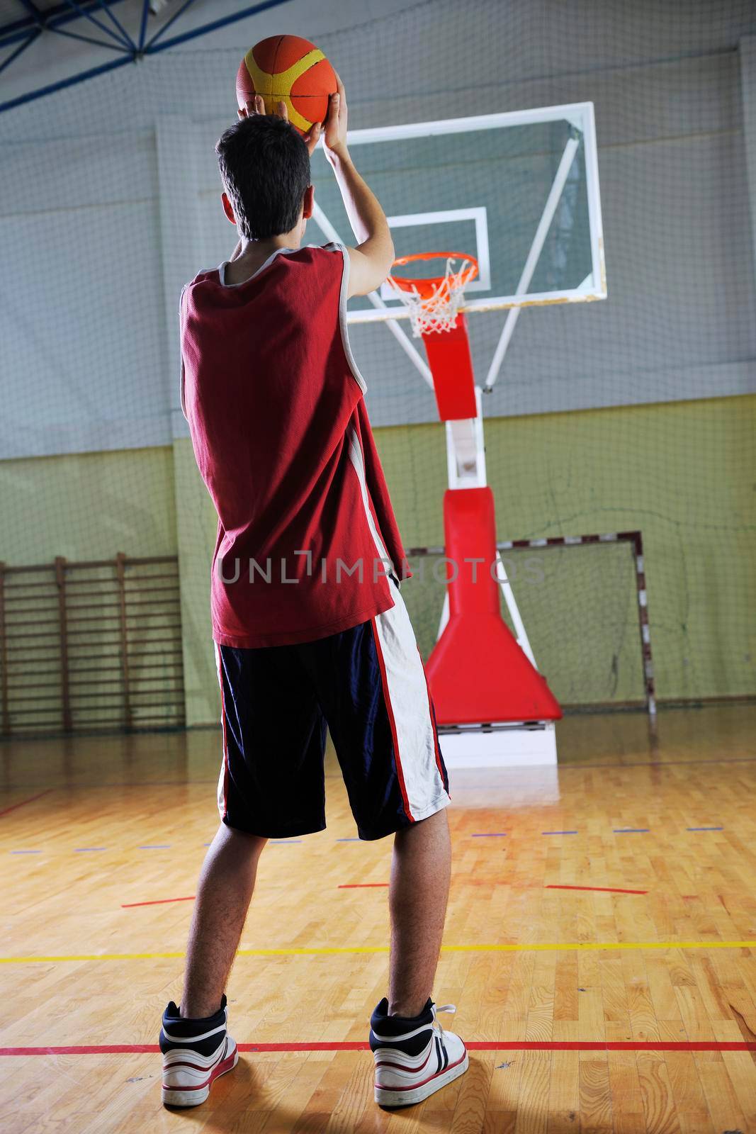 young healthy man play basketball game indoor in gym