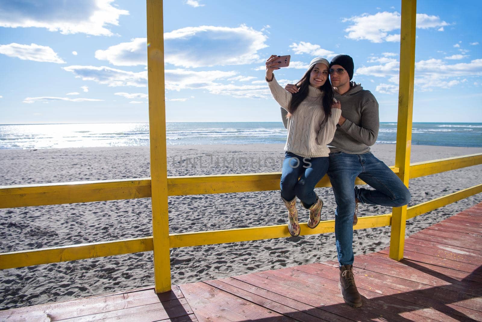 Very Happy Couple In Love Taking Selfie On The Beach in autmun day