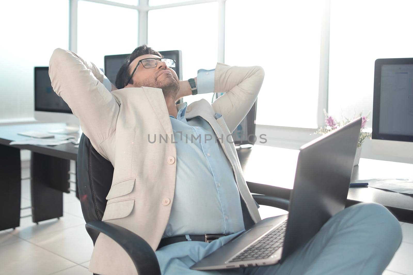 tired businessman sitting in front of his Desk.office weekdays