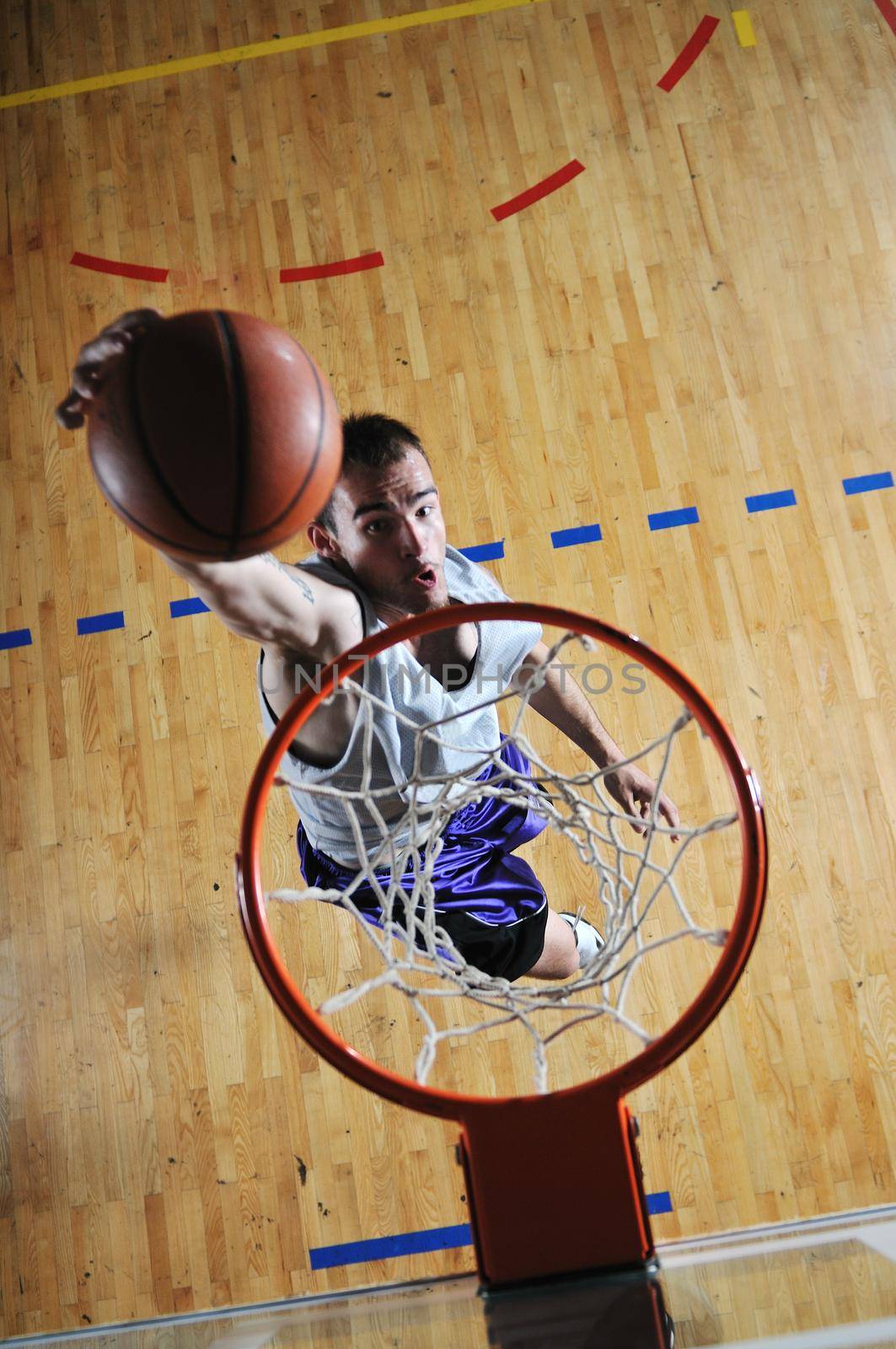 one healthy young  man play basketball game in school gym indoor