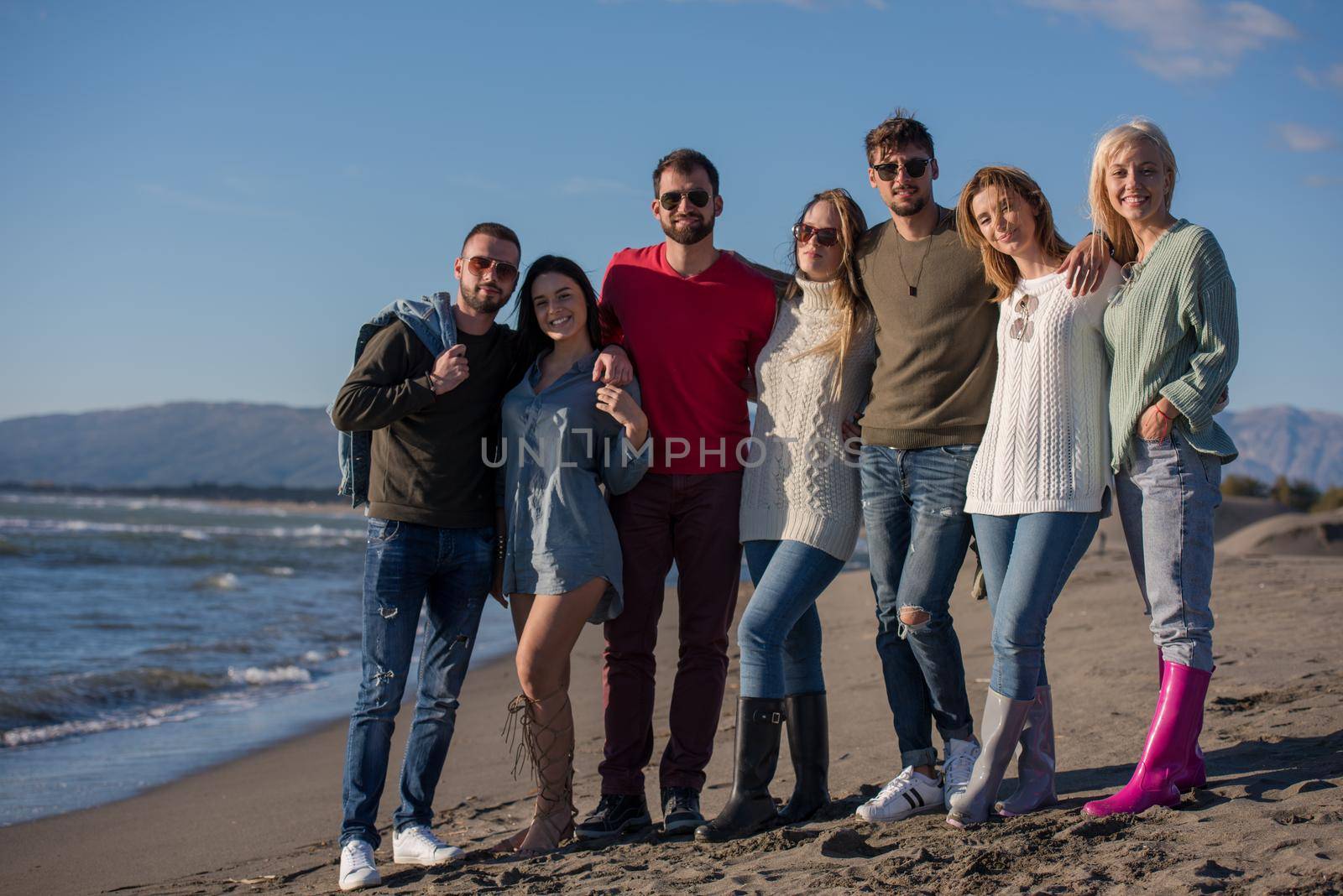 portrait of friends having fun on beach during autumn day by dotshock