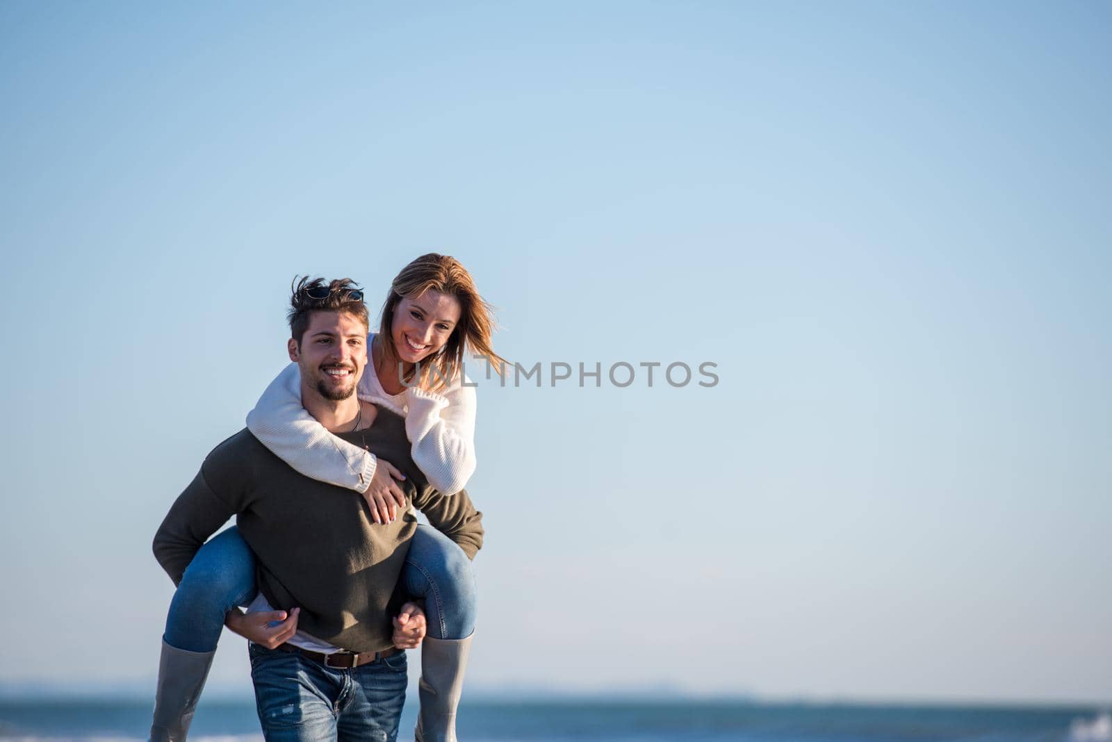couple having fun at beach during autumn by dotshock