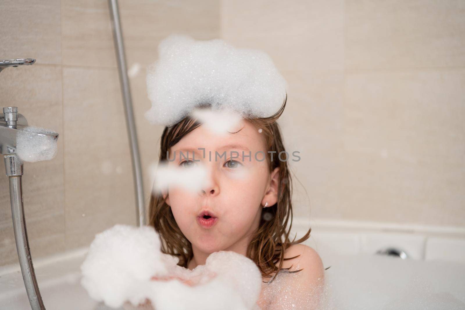 little girl in bath playing with foam by dotshock