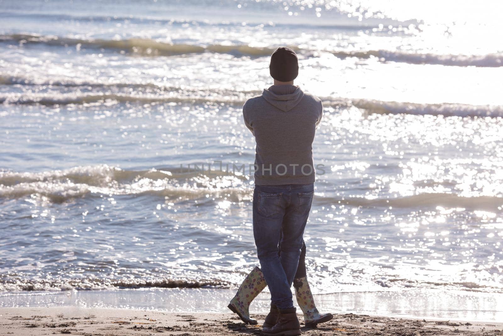 Loving young couple on a beach at autumn sunny day by dotshock