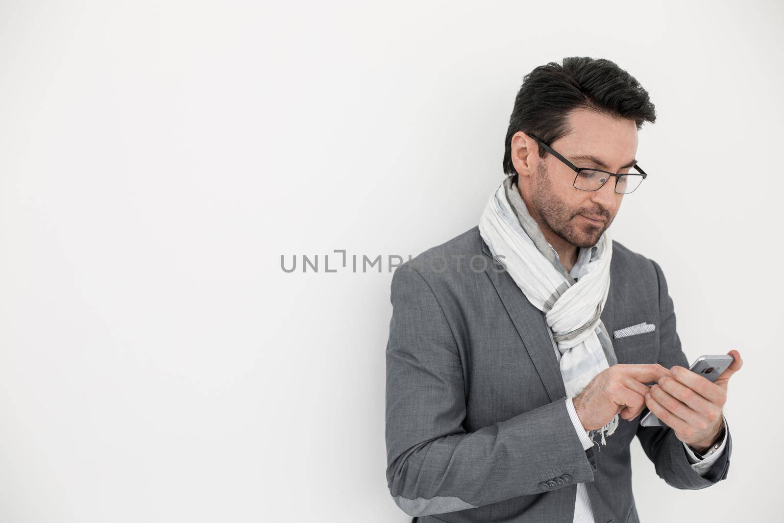businessman with scarf on neck typing SMS on smartphone.photo with copy space