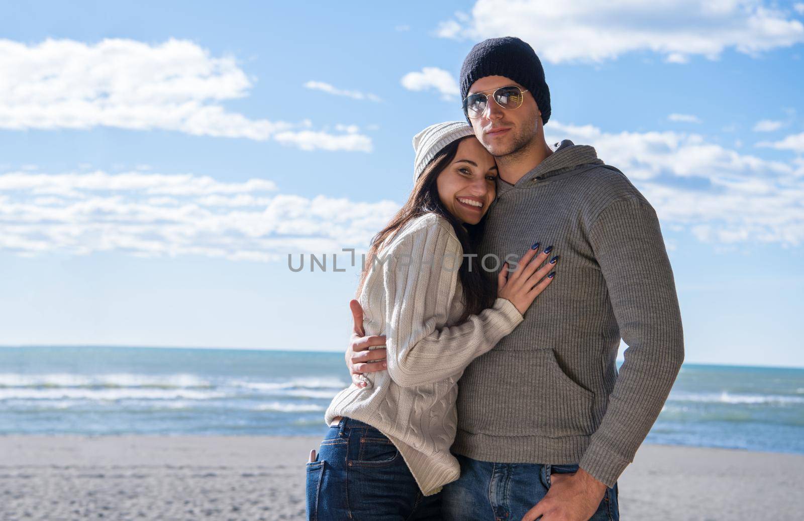 Happy couple enyojing time together on beach during autumn day