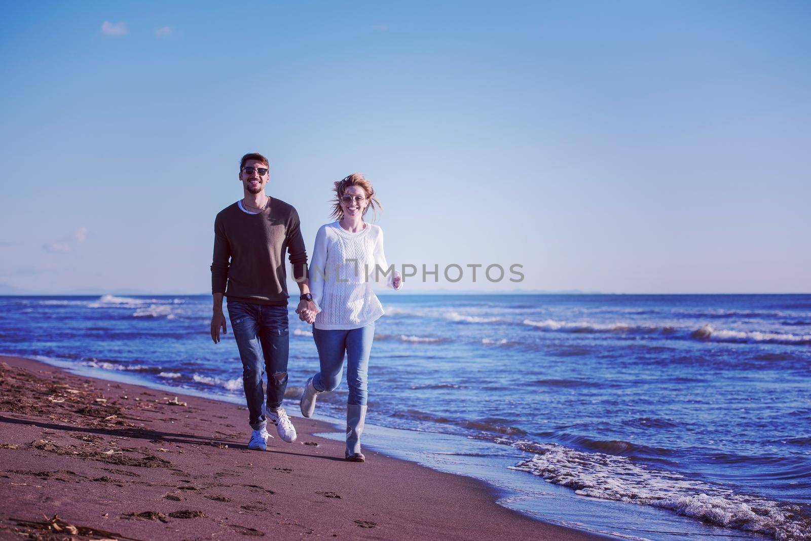 Loving young couple on a beach at autumn sunny day by dotshock