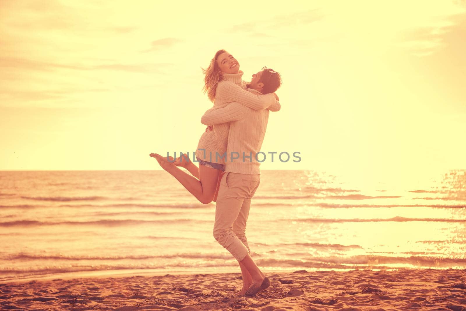 Loving young couple on a beach at autumn sunny day by dotshock