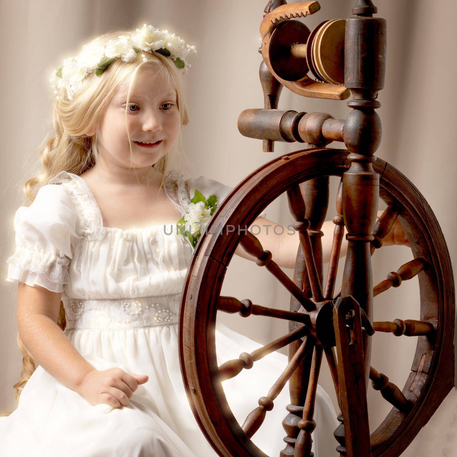 A cute little girl wove a wool with a rotating wheel. by kolesnikov_studio
