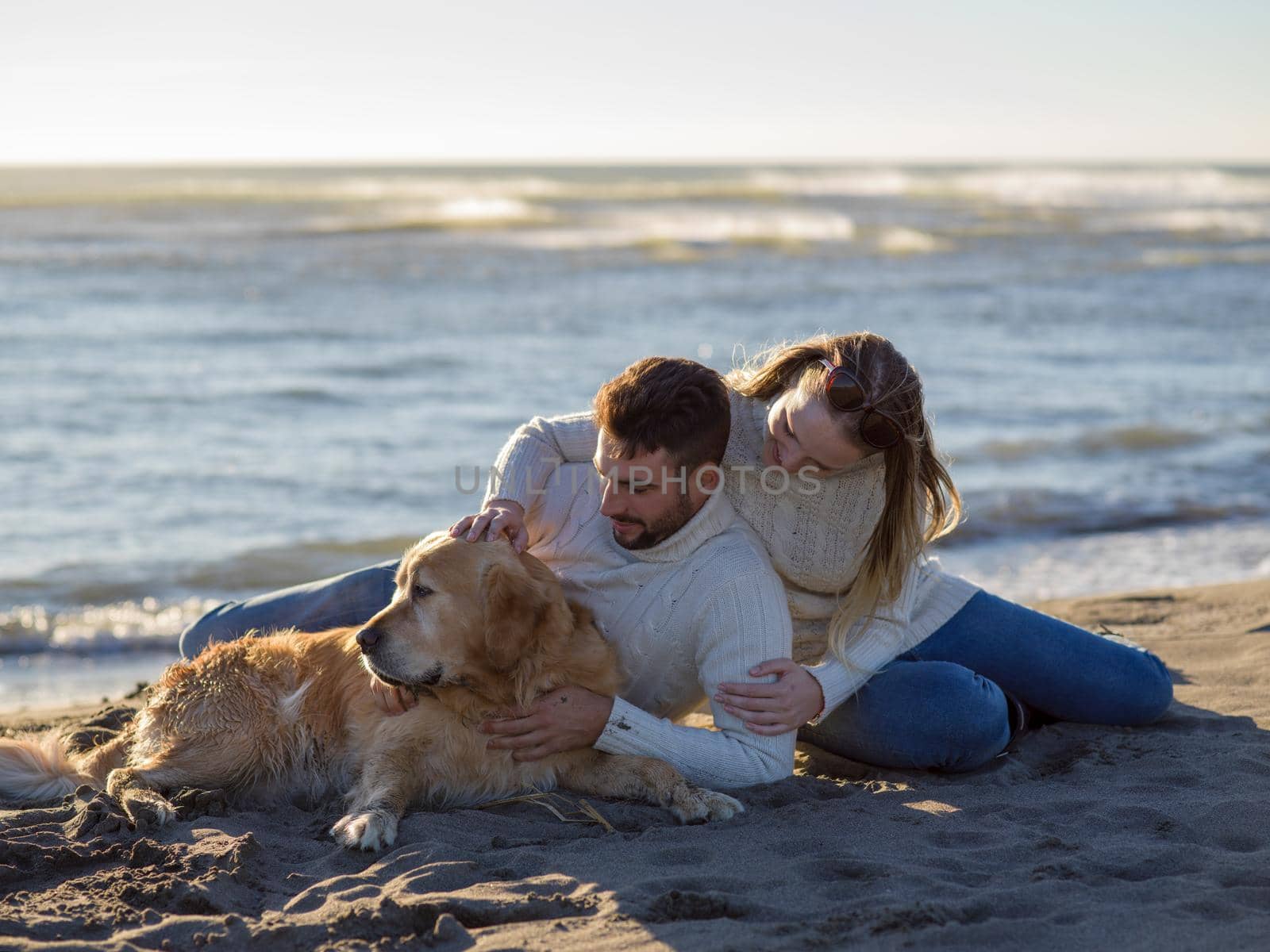 Couple with dog enjoying time on beach by dotshock