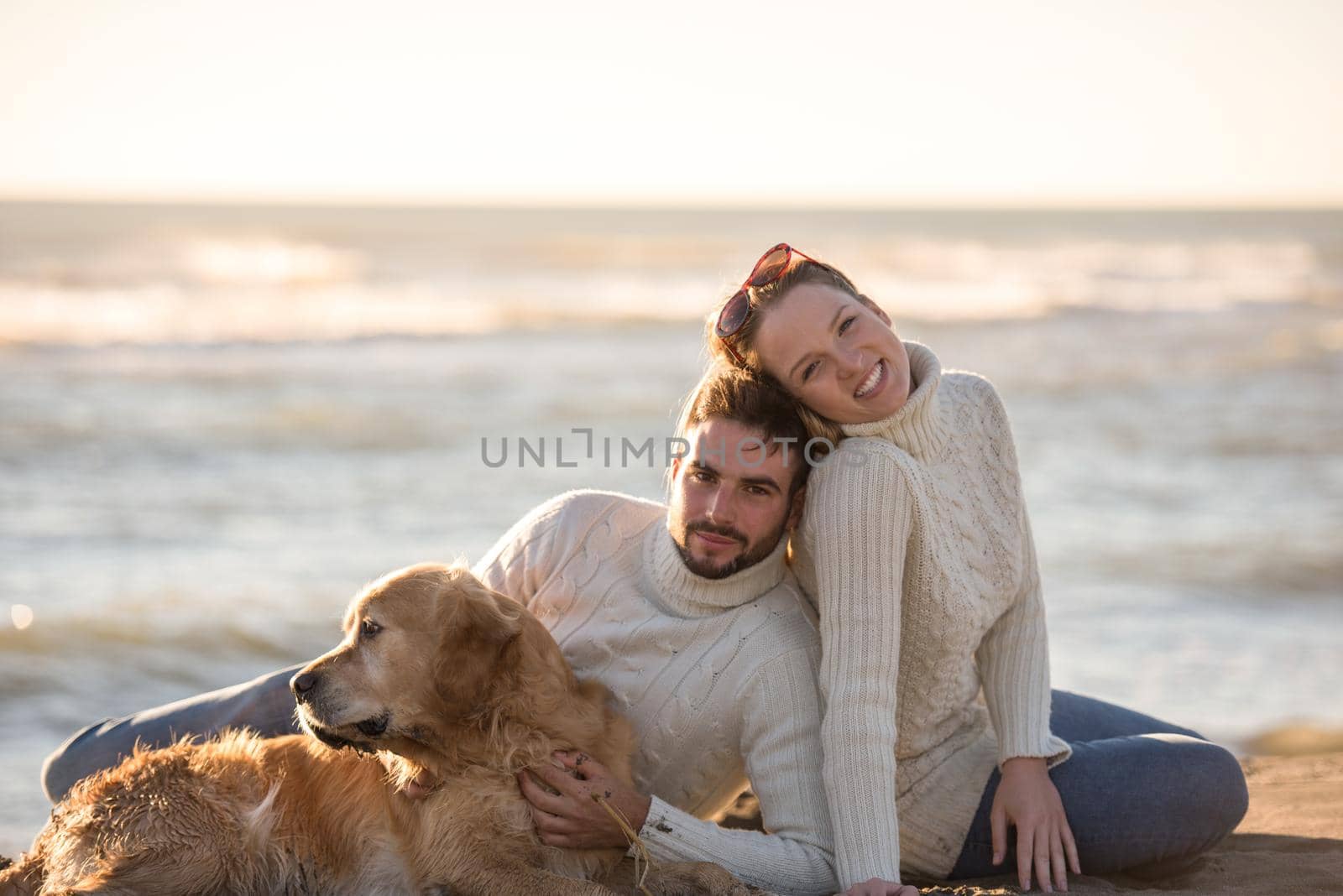 Couple with dog enjoying time on beach by dotshock