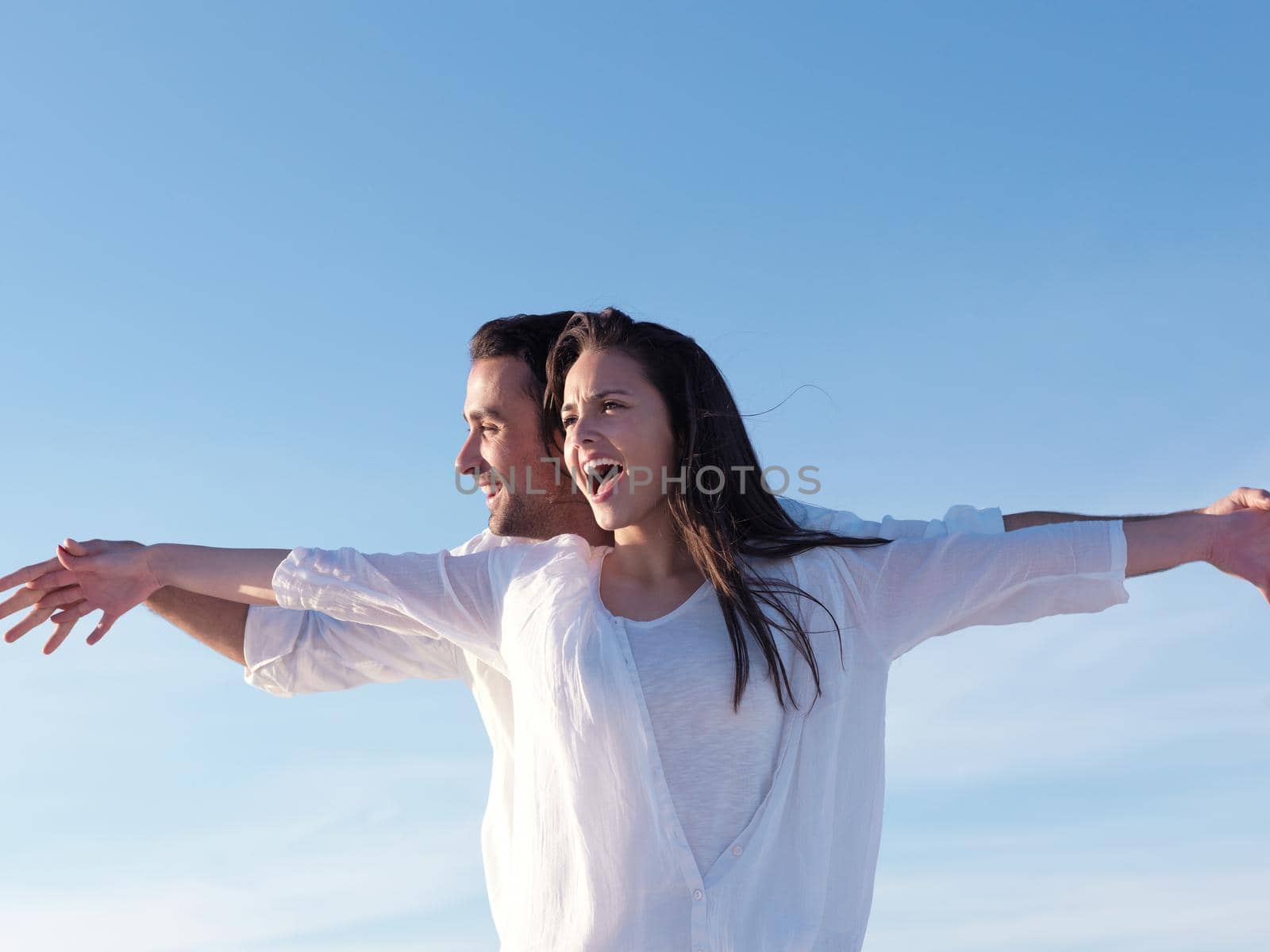 happy young romantic couple in love have fun on beautiful beach at beautiful summer day