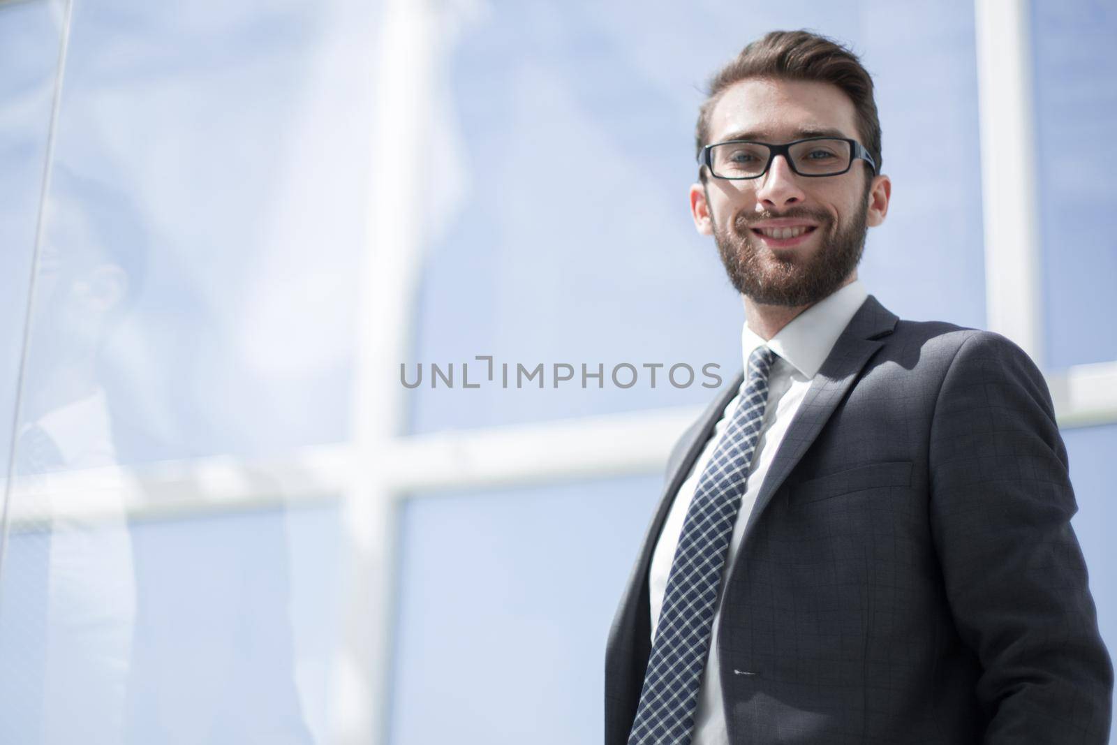 smiling businessman on the background of the office window .photo with copy space