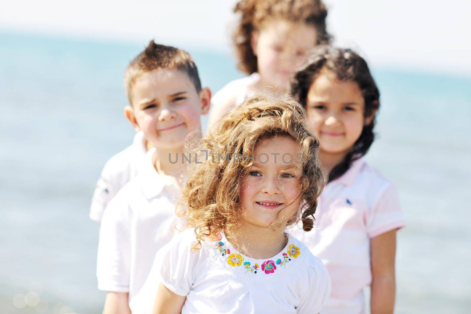 group of happy child on beach who have fun and play games