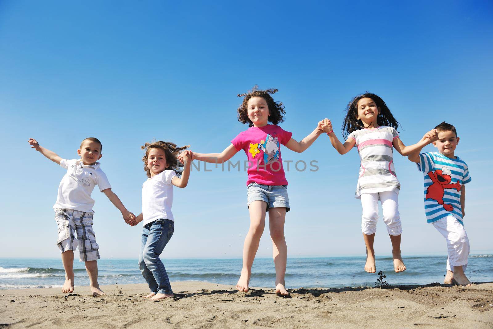 group of happy child on beach who have fun and play games