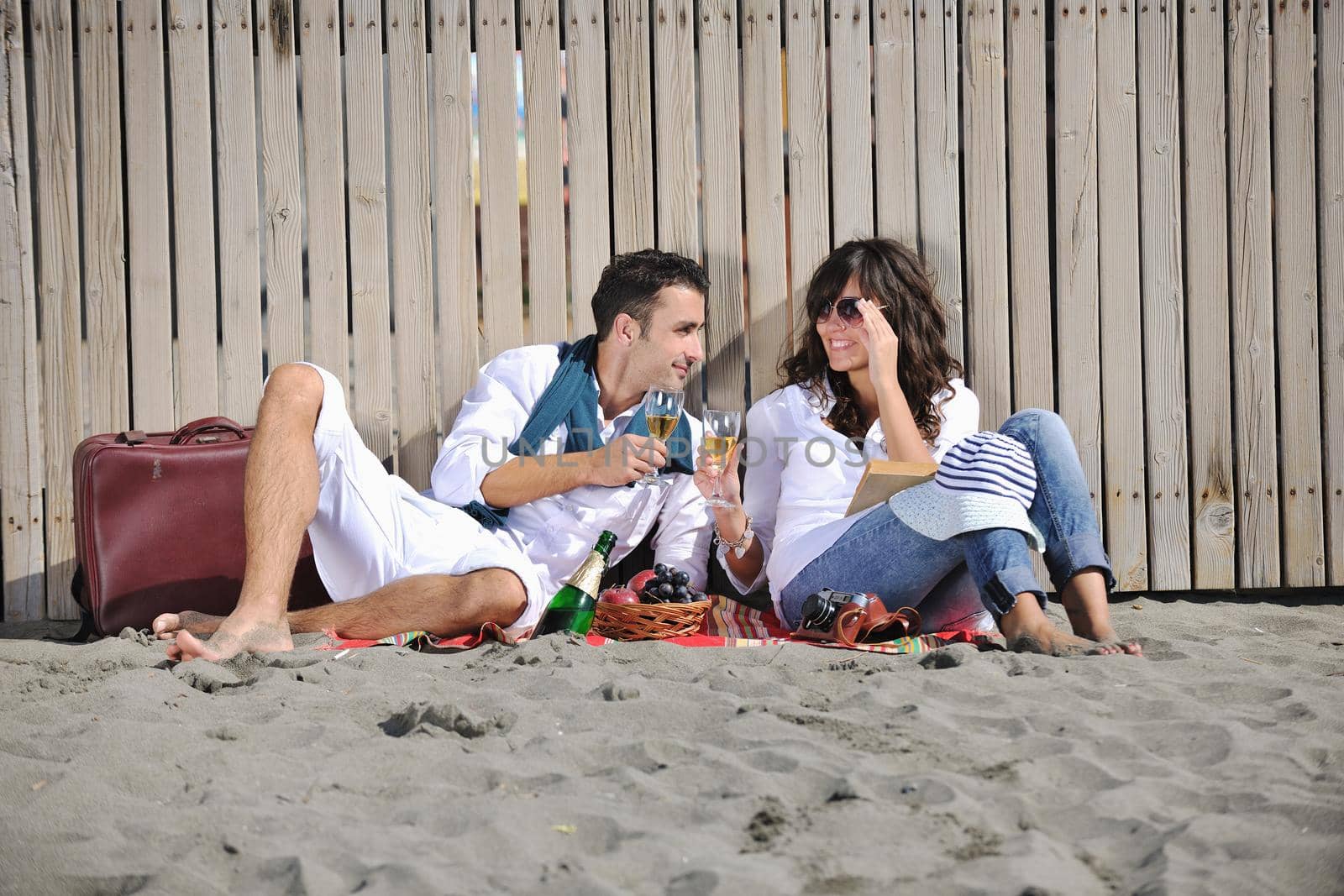 young couple enjoying  picnic on the beach by dotshock