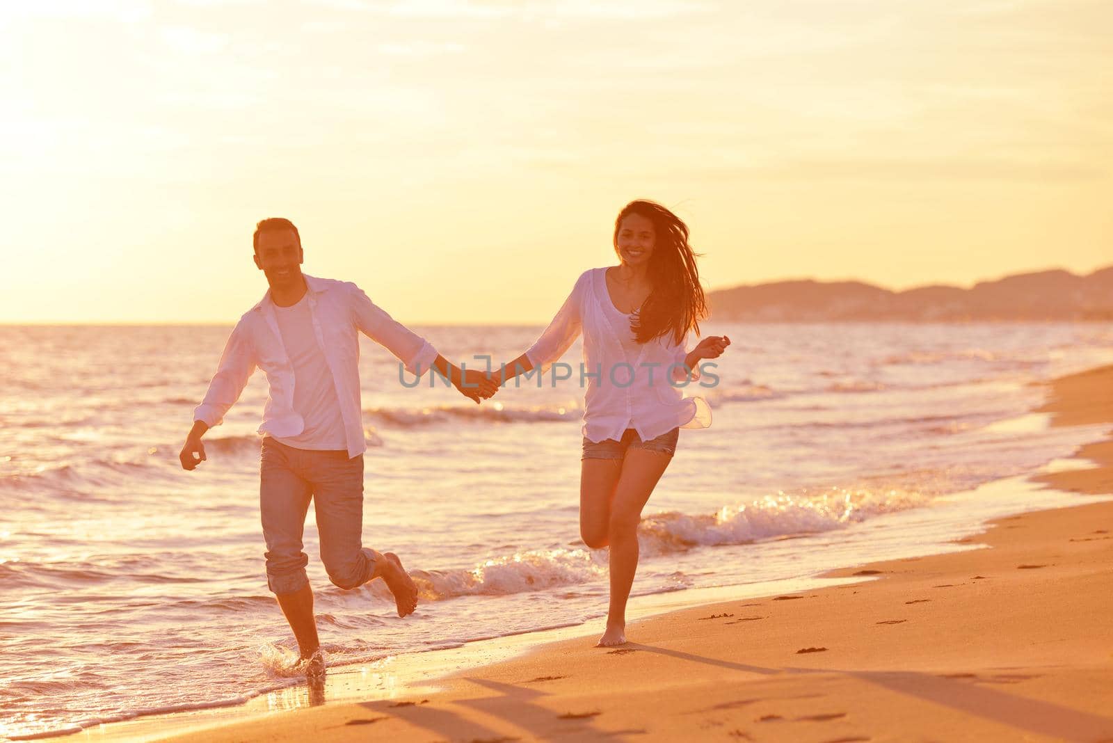 happy young romantic couple in love have fun on beautiful beach at beautiful summer day