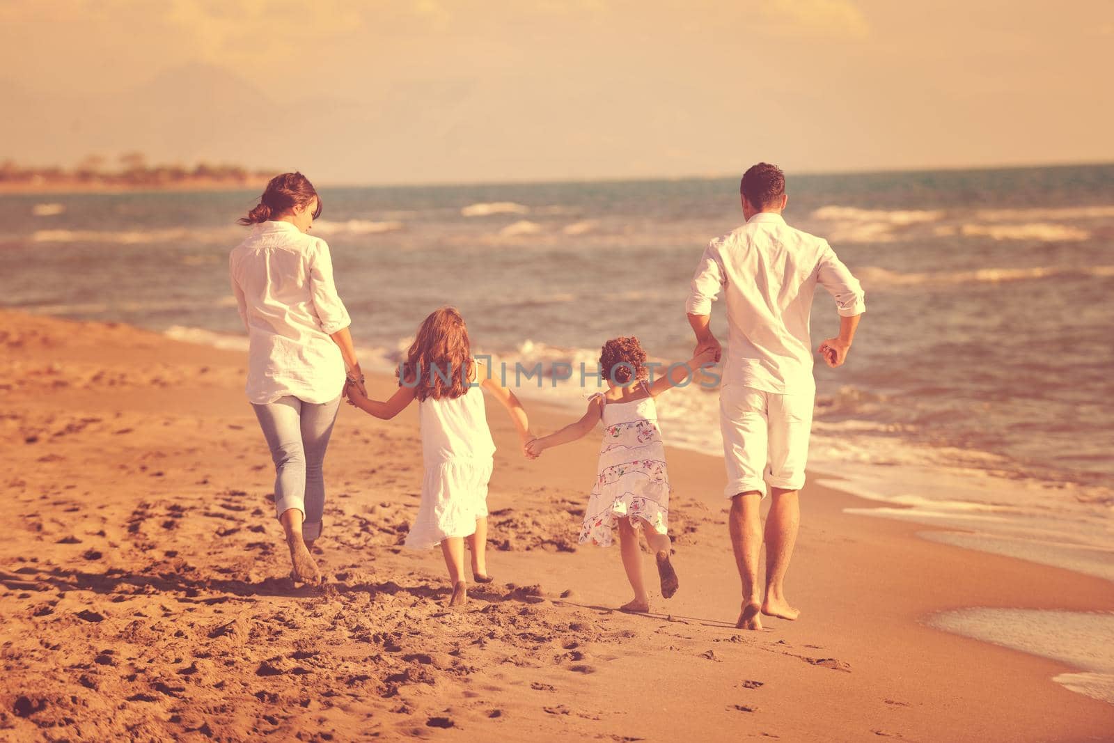 happy young family in white clothing have fun at vacations on beautiful beach 