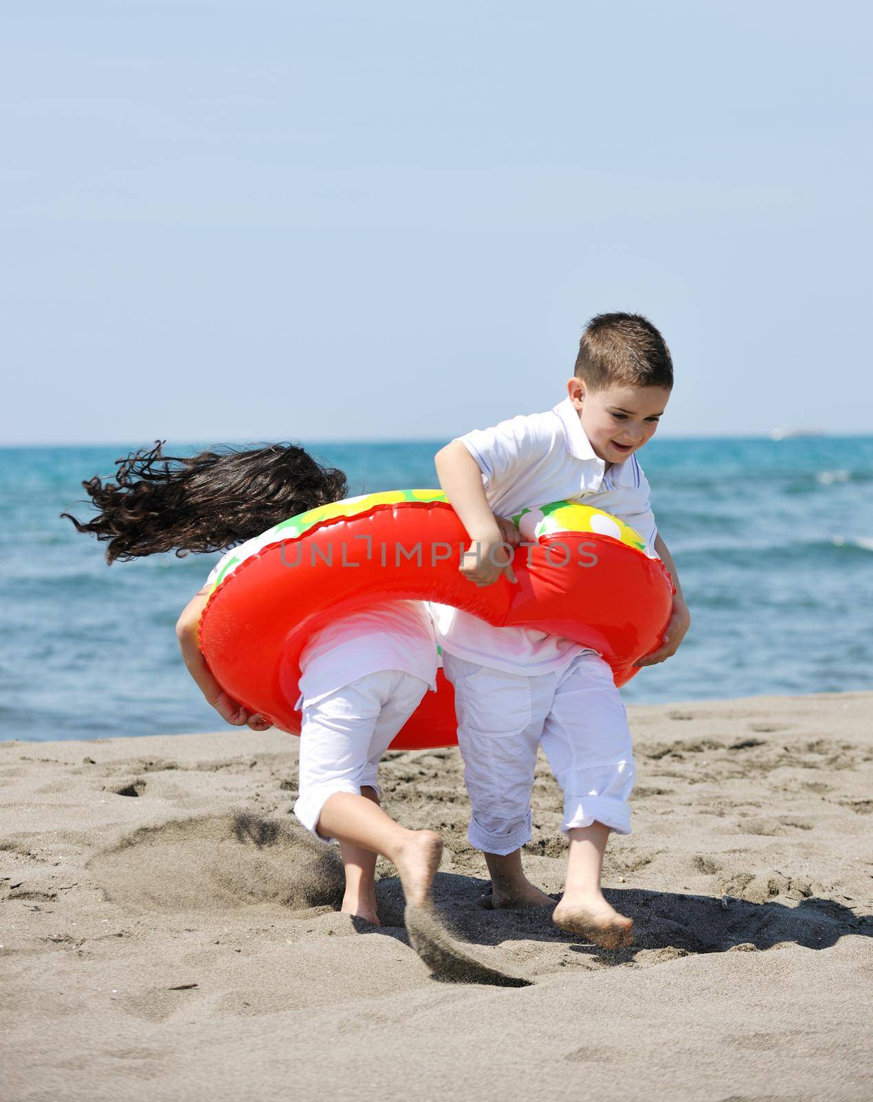 group of happy child on beach who have fun and play games